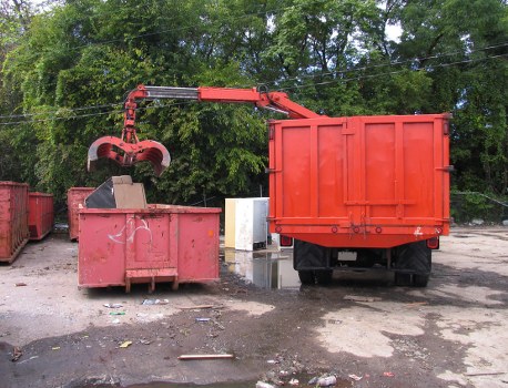 Operatives wearing PPE and loading a skip